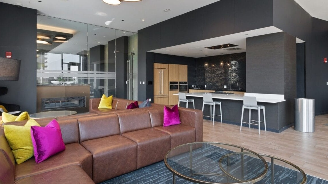An open-concept lounge and kitchen area with modern appliances and comfortable seating at Moment Apartments in Chicago