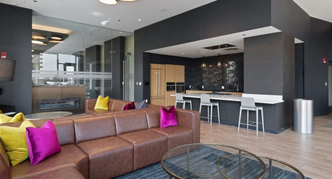 An open-concept lounge and kitchen area with modern appliances and comfortable seating at Moment Apartments in Chicago