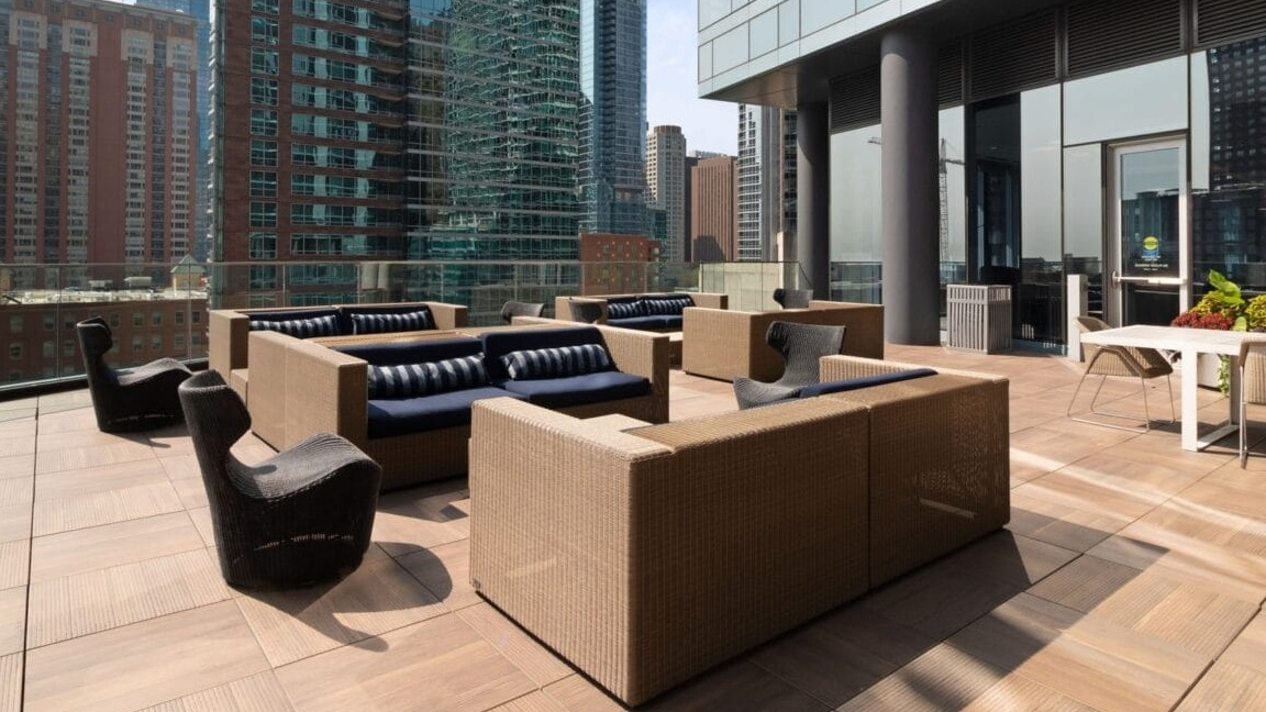 Expansive outdoor lounge at Moment Apartments in Chicago, featuring comfortable seating and stunning views of the surrounding city skyscrapers