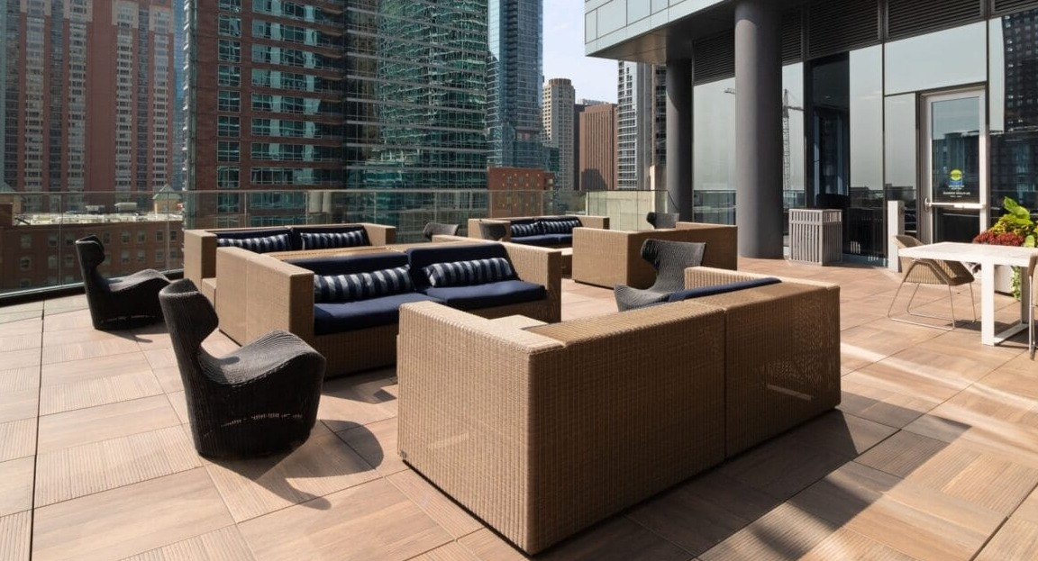Expansive outdoor lounge at Moment Apartments in Chicago, featuring comfortable seating and stunning views of the surrounding city skyscrapers