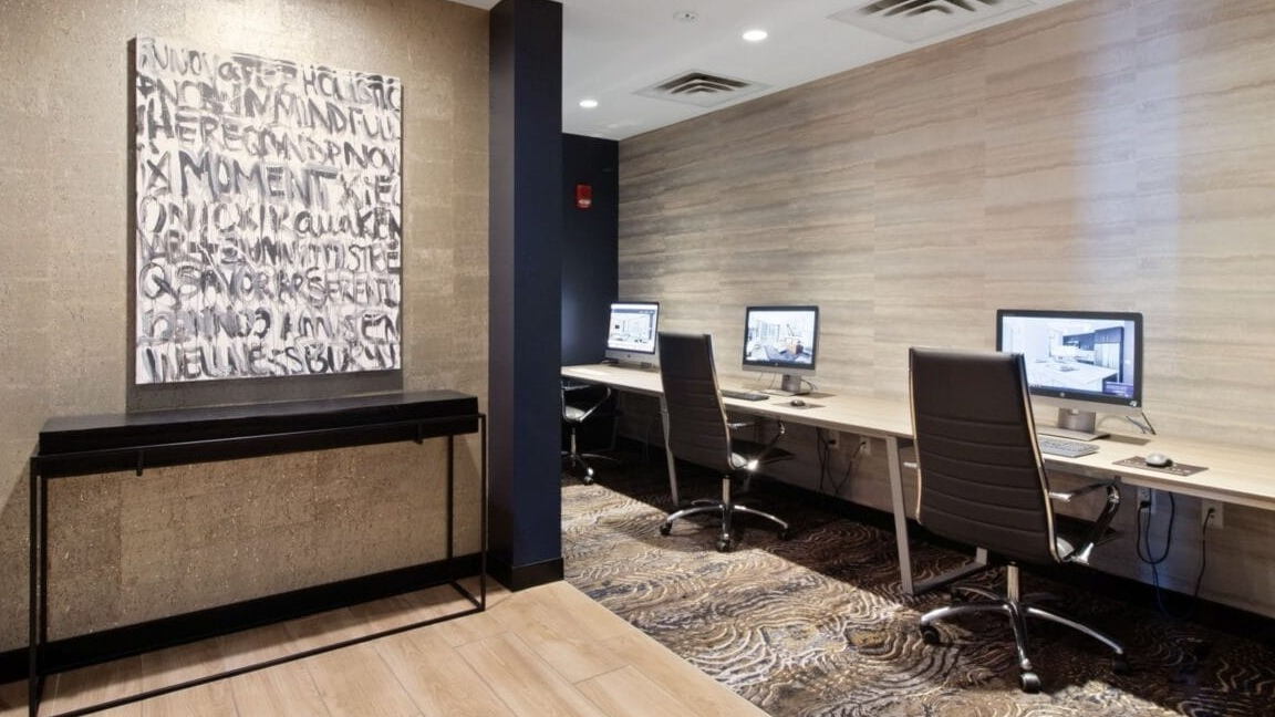 Dedicated resident work stations with computers and office chairs, ideal for productivity at Moment Apartments in Chicago