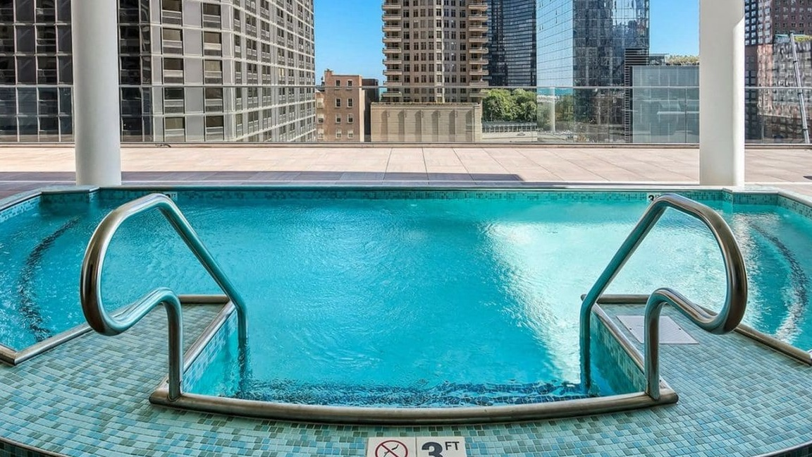 A rooftop hot tub with stunning city skyline views, perfect for relaxation at Moment Apartments in Chicago