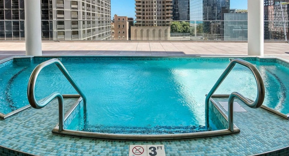 A rooftop hot tub with stunning city skyline views, perfect for relaxation at Moment Apartments in Chicago