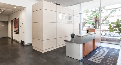 Welcoming reception lobby with a modern desk, Mondial River West branding, and large windows at the apartment entrance in Chicago