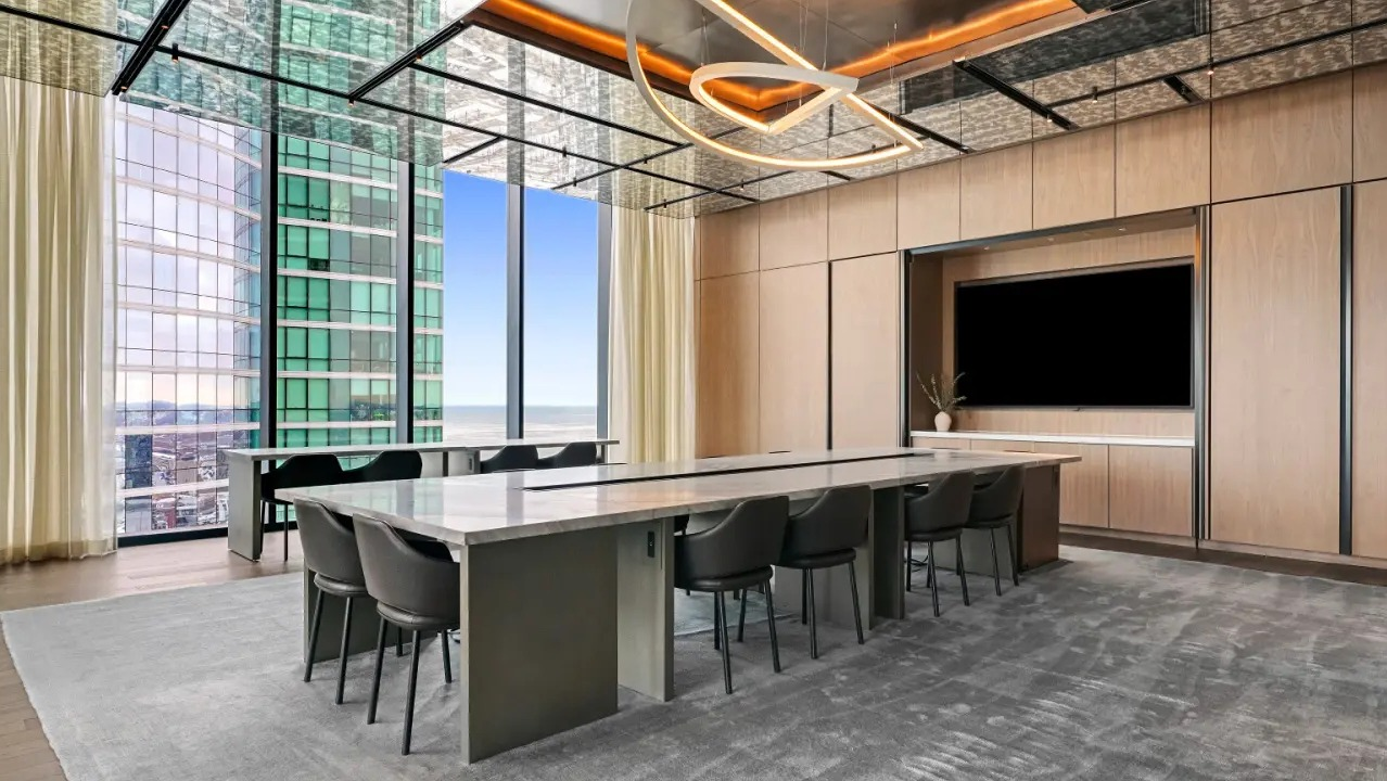 Luxurious conference room at NEMA Chicago, featuring a large table, modern seating, and stunning city views through expansive windows