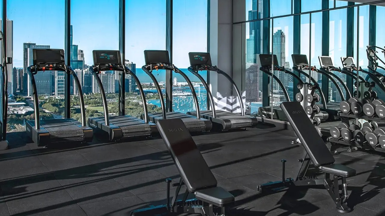 State-of-the-art gym at NEMA Chicago, featuring cardio and weight training equipment with incredible city skyline views