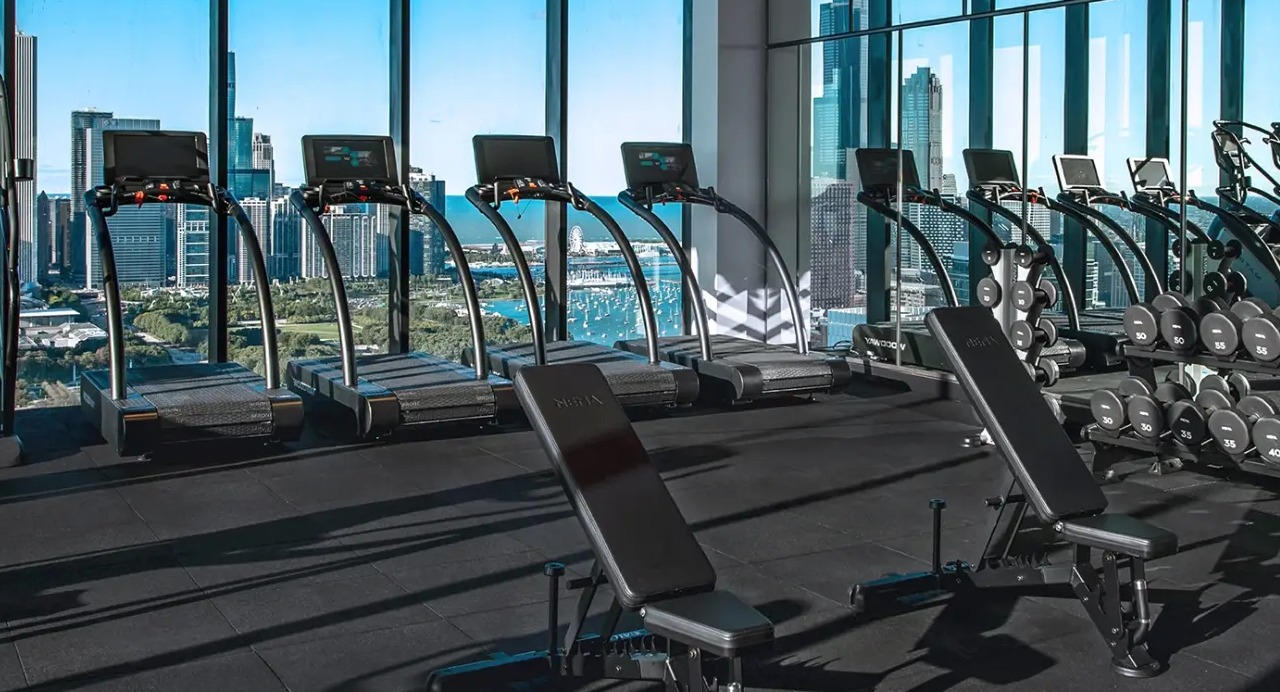 State-of-the-art gym at NEMA Chicago, featuring cardio and weight training equipment with incredible city skyline views
