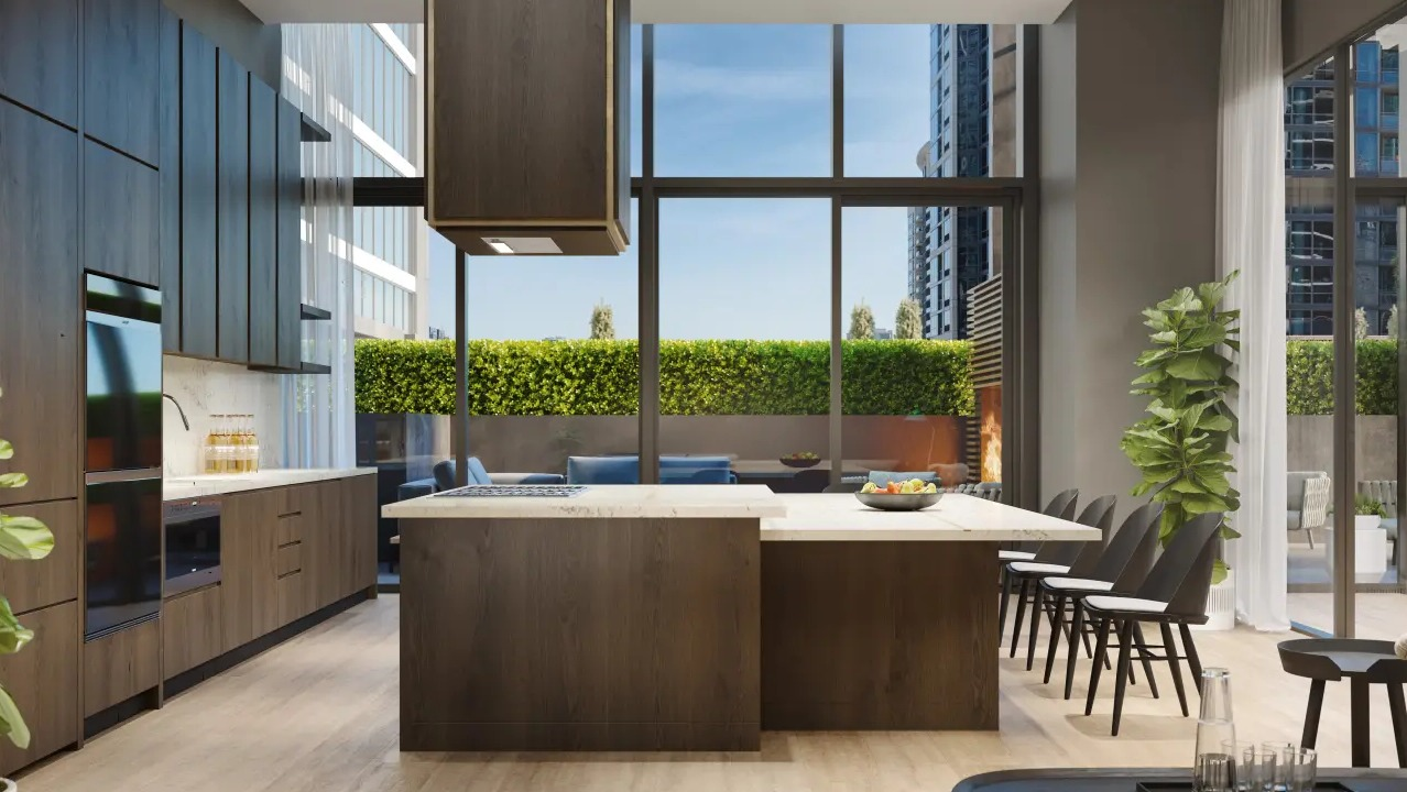 Modern resident kitchen and lounge area at NEMA Chicago, featuring an island, dining space, and access to a lush outdoor terrace