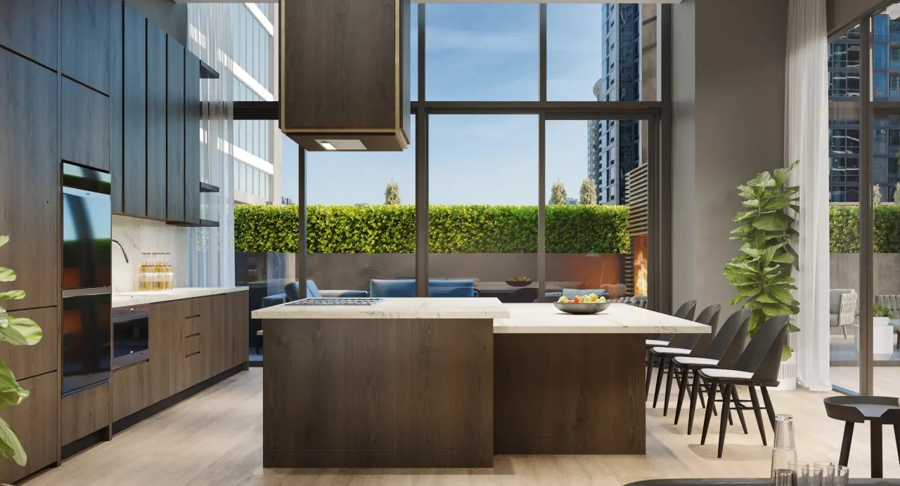 Modern resident kitchen and lounge area at NEMA Chicago, featuring an island, dining space, and access to a lush outdoor terrace