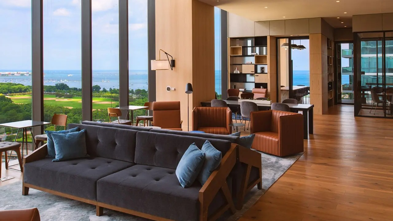 Elegant resident lounge at NEMA Chicago, featuring comfortable seating, a stylish workspace, and expansive views of Lake Michigan