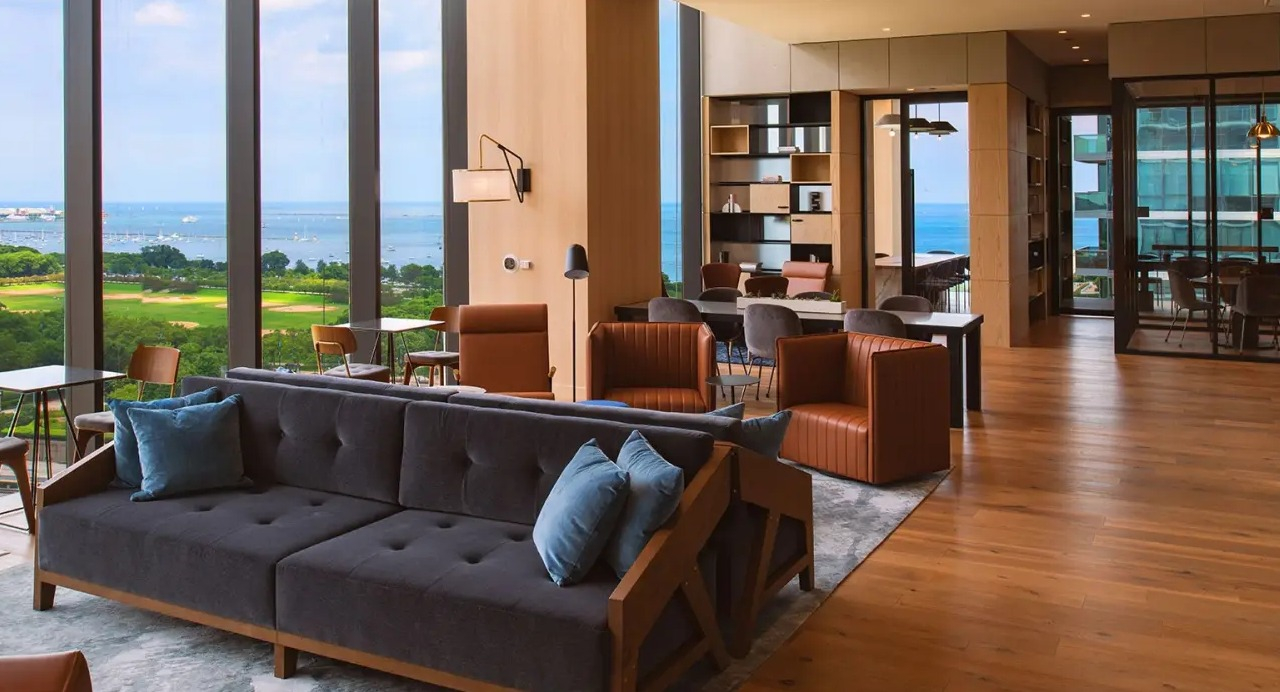 Elegant resident lounge at NEMA Chicago, featuring comfortable seating, a stylish workspace, and expansive views of Lake Michigan