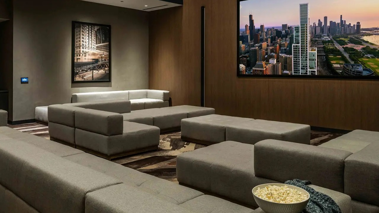 Luxurious screening room at NEMA Chicago, featuring plush seating, a large screen, and a bowl of popcorn for an ultimate movie experience
