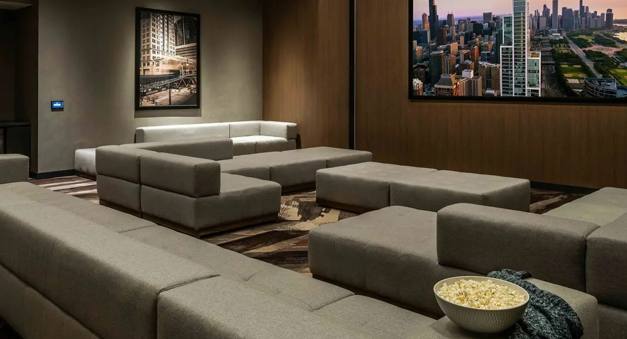 Luxurious screening room at NEMA Chicago, featuring plush seating, a large screen, and a bowl of popcorn for an ultimate movie experience