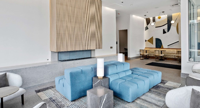 Grand lobby lounge at Nevele22 in Chicago, featuring a modern fireplace, stylish blue modular seating, and elegant lighting