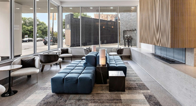 Inviting lobby lounge at Nevele22 in Chicago, featuring a contemporary design with a blue modular sofa, elegant lighting, and large windows
