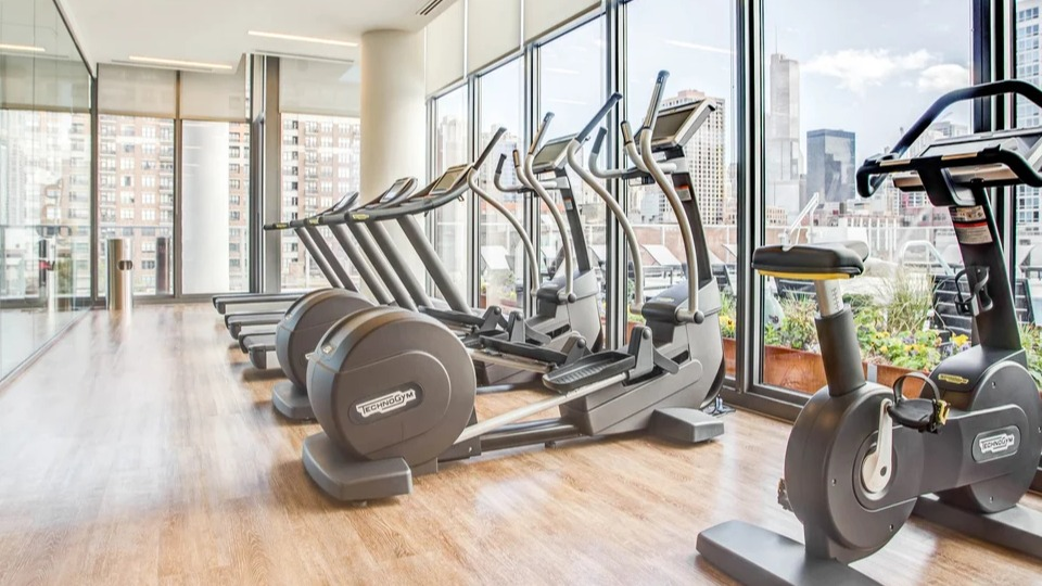 State-of-the-art fitness center with cardio equipment, weights, and expansive city views at NEXT Apartments in Chicago