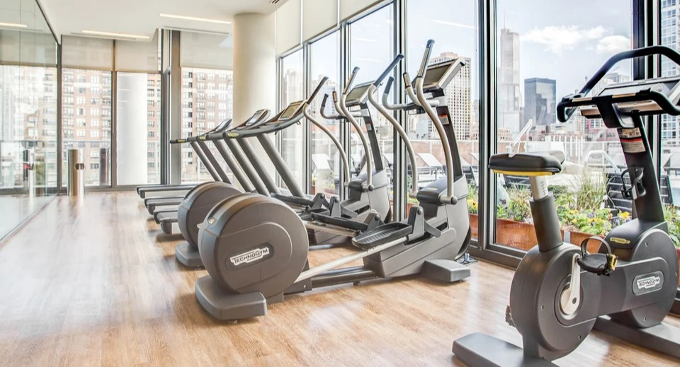 State-of-the-art fitness center with cardio equipment, weights, and expansive city views at NEXT Apartments in Chicago
