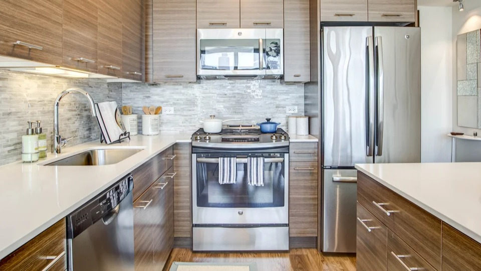 Modern kitchen equipped with stainless steel appliances, sleek cabinetry, and stylish tile backsplash at NEXT Apartments Chicago