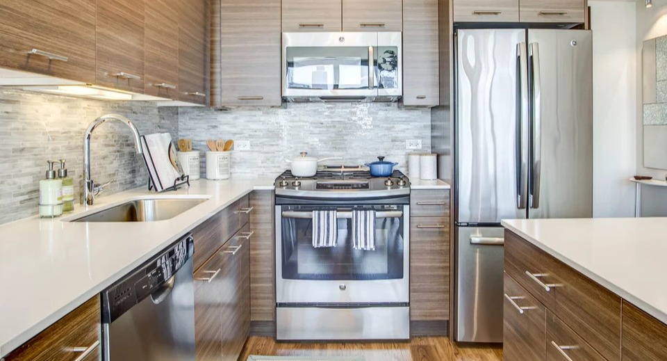 Modern kitchen equipped with stainless steel appliances, sleek cabinetry, and stylish tile backsplash at NEXT Apartments Chicago
