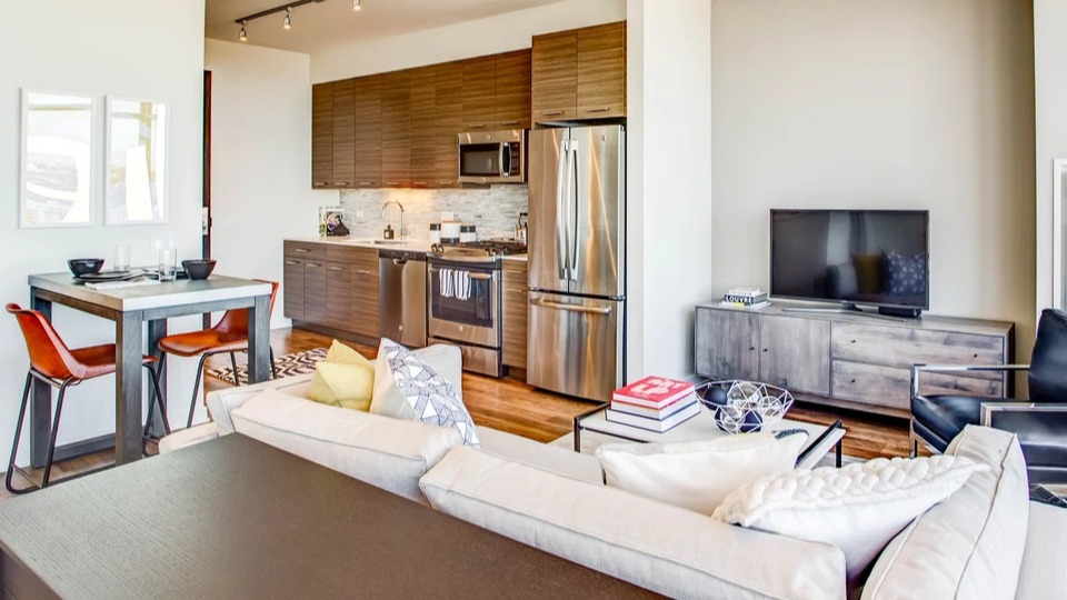 Modern kitchen and living area with stainless steel appliances and comfortable seating for urban living at NEXT Apartments Chicago