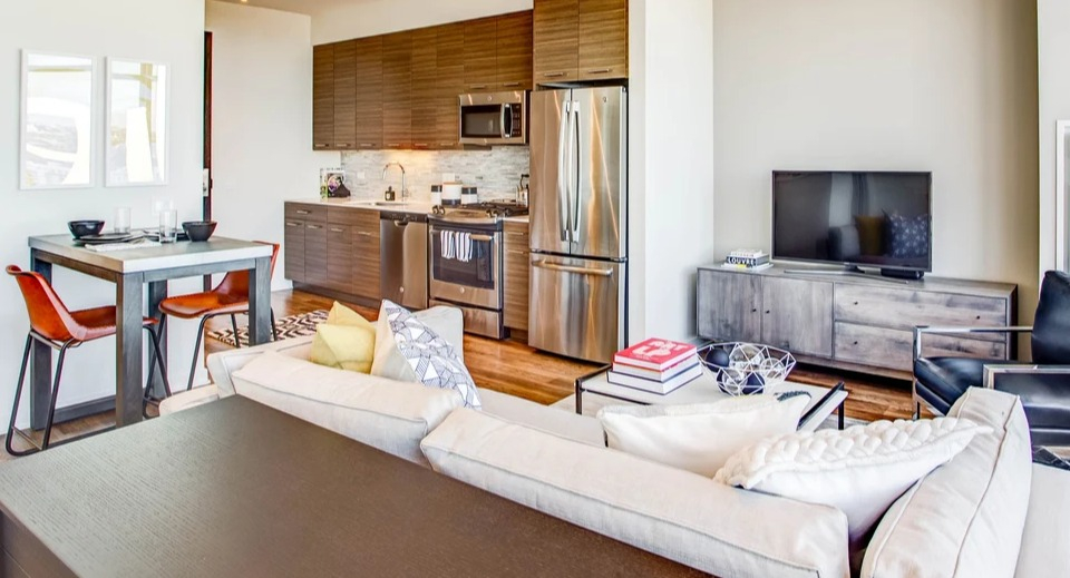 Modern kitchen and living area with stainless steel appliances and comfortable seating for urban living at NEXT Apartments Chicago