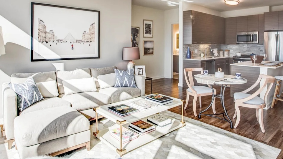 Spacious open-concept living room and kitchen area with modern furnishings, ideal for entertaining at NEXT Apartments Chicago