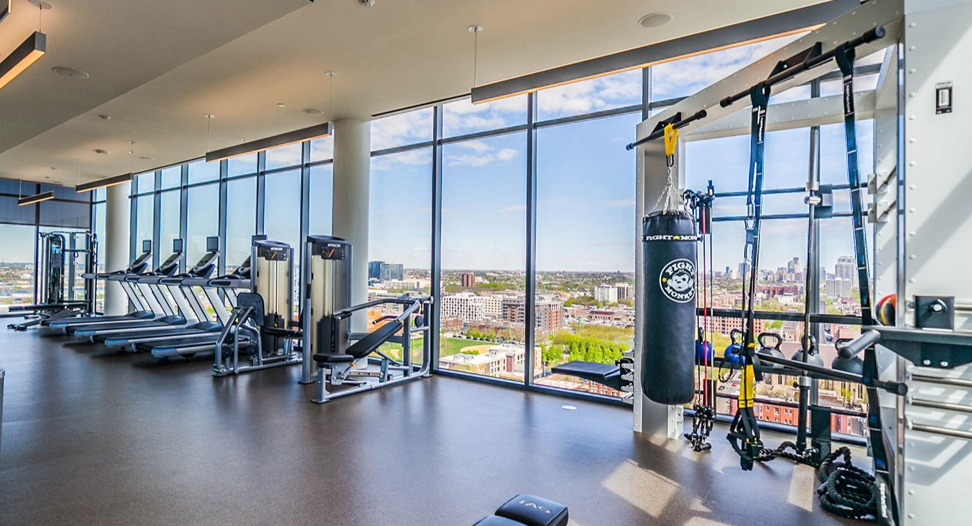 State-of-the-art fitness center at Niche 905 in Chicago, featuring a variety of cardio and strength equipment with panoramic city views