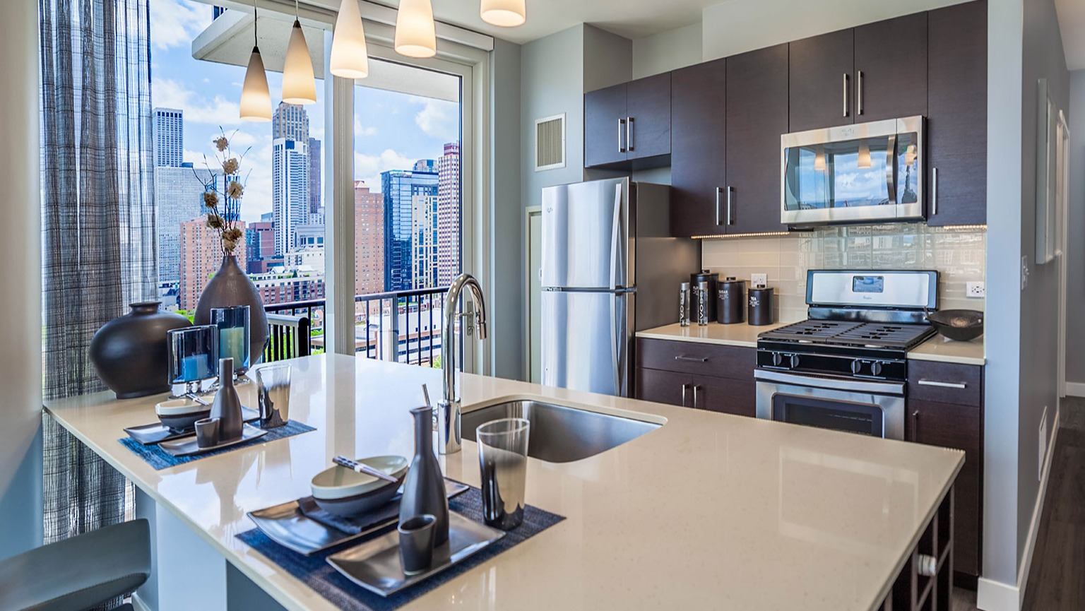 Contemporary apartment kitchen at Niche 905 in Chicago, featuring a large island, sleek appliances, and a seamless connection to the living space