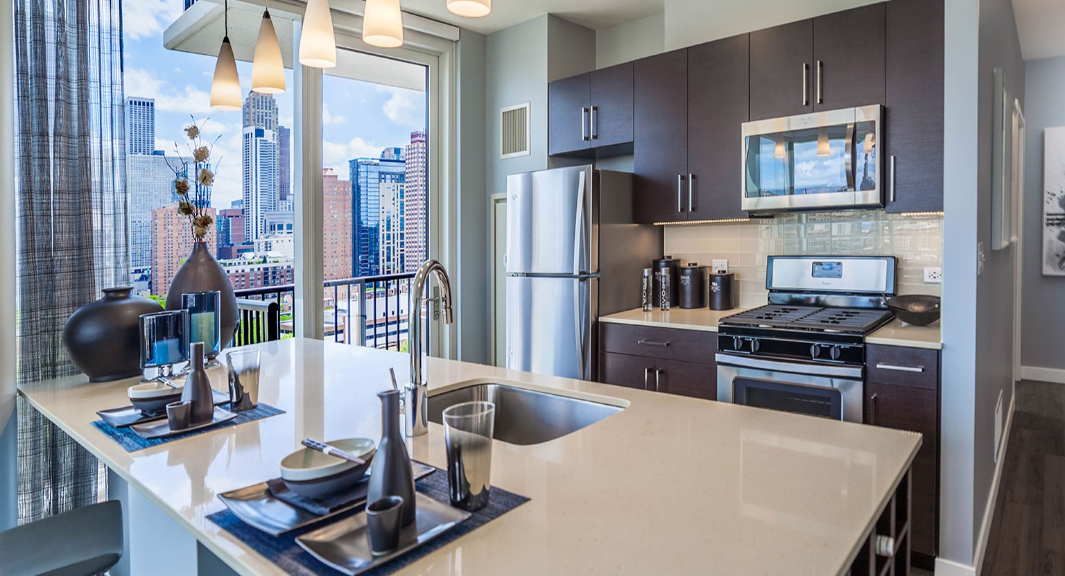 Contemporary apartment kitchen at Niche 905 in Chicago, featuring a large island, sleek appliances, and a seamless connection to the living space