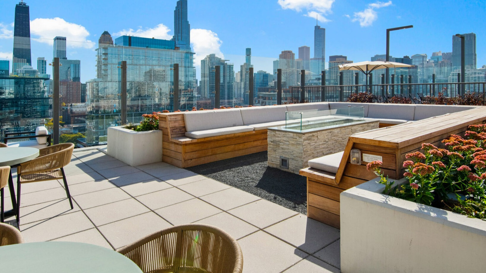 Luxurious rooftop lounge at Niche 905 in Chicago, featuring comfortable seating, a modern fire pit, and expansive city views