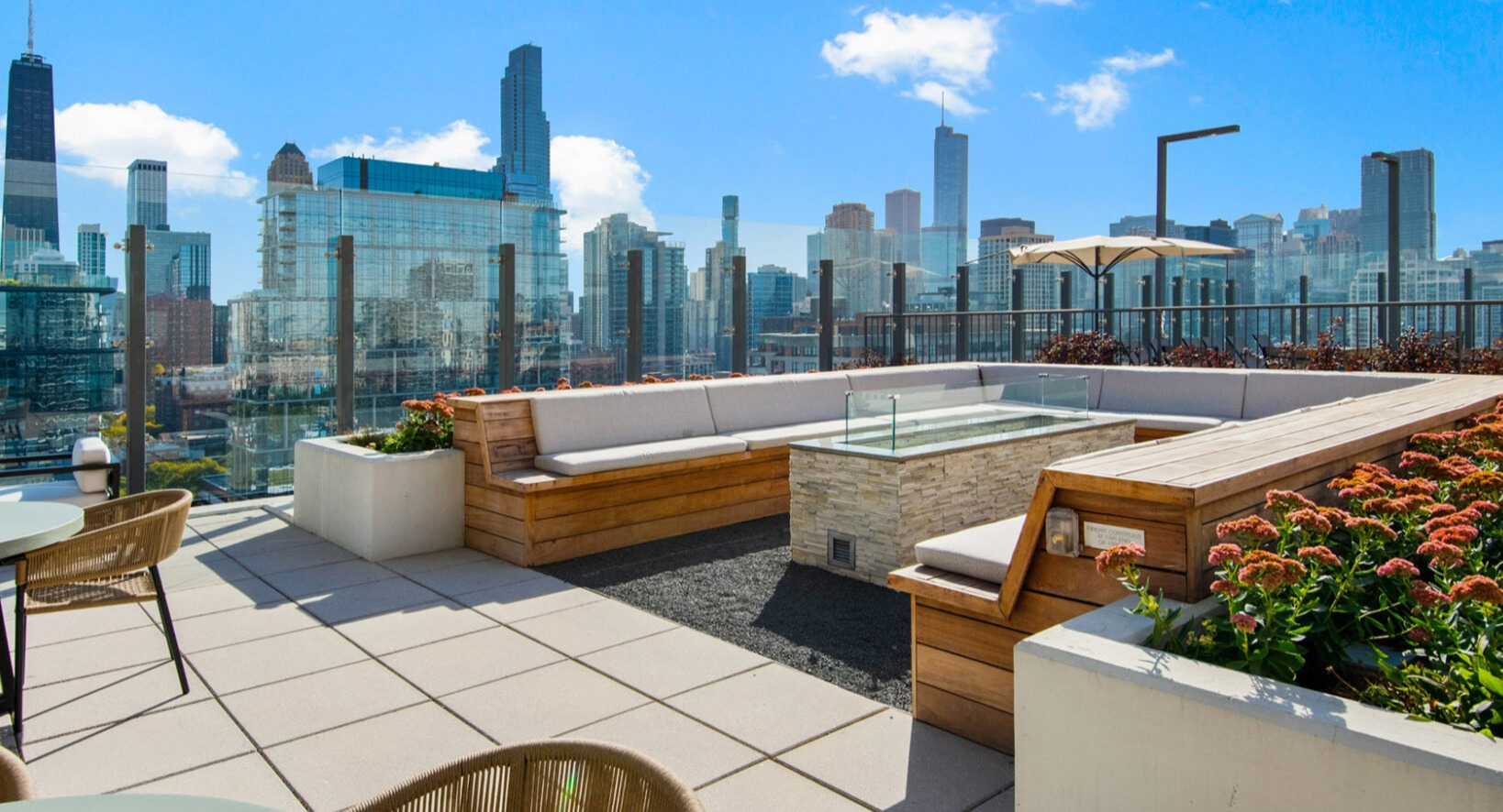 Luxurious rooftop lounge at Niche 905 in Chicago, featuring comfortable seating, a modern fire pit, and expansive city views