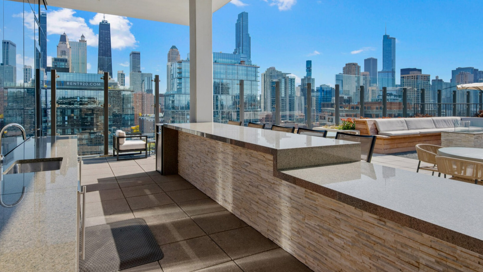 Spacious rooftop outdoor kitchen at Niche 905 in Chicago, featuring built-in grills, ample counter space, and impressive city views
