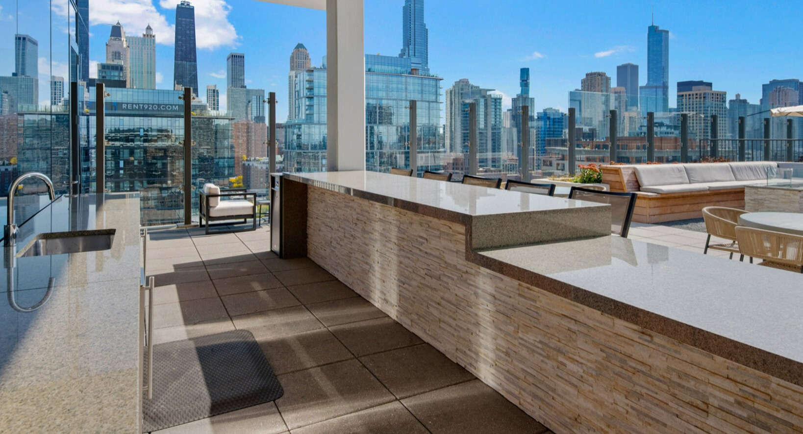 Spacious rooftop outdoor kitchen at Niche 905 in Chicago, featuring built-in grills, ample counter space, and impressive city views
