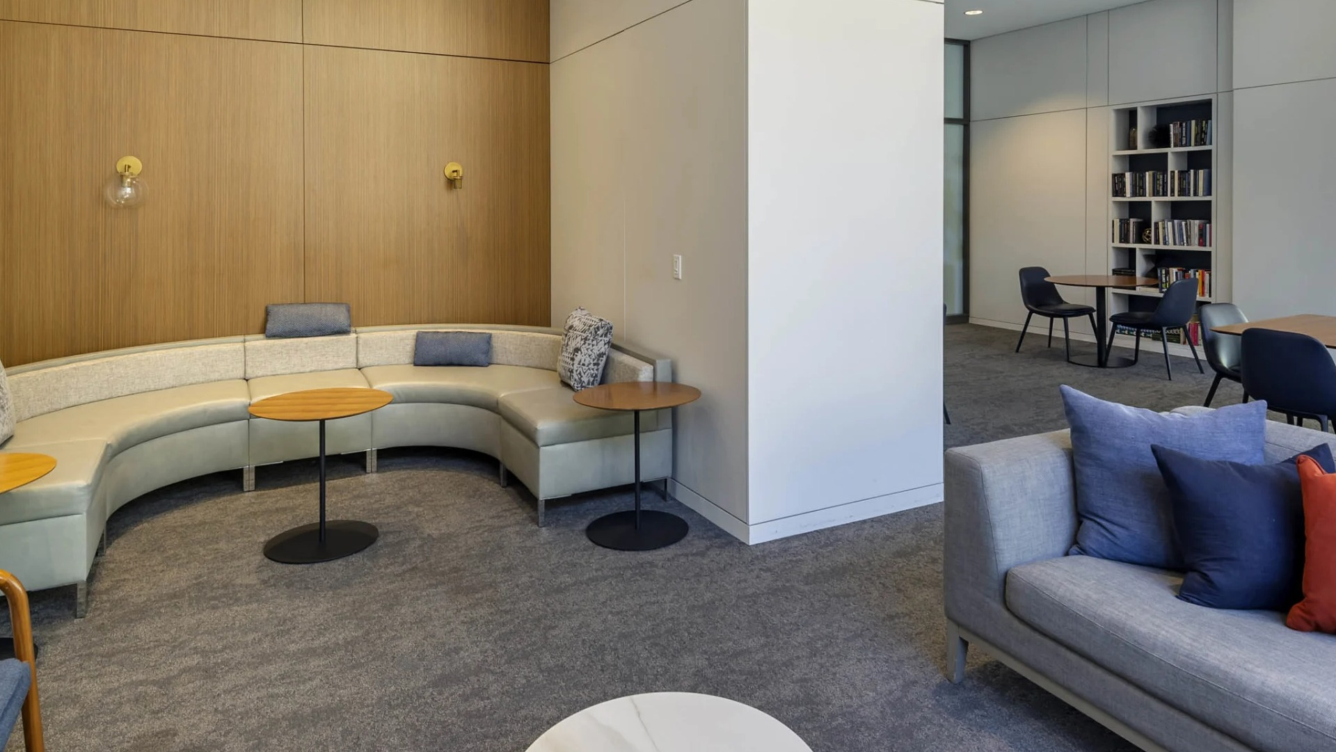 Cozy lounge at North Harbor Tower in Chicago with curved banquette seating, modern sofas, accent pillows, and adjoining reading areas