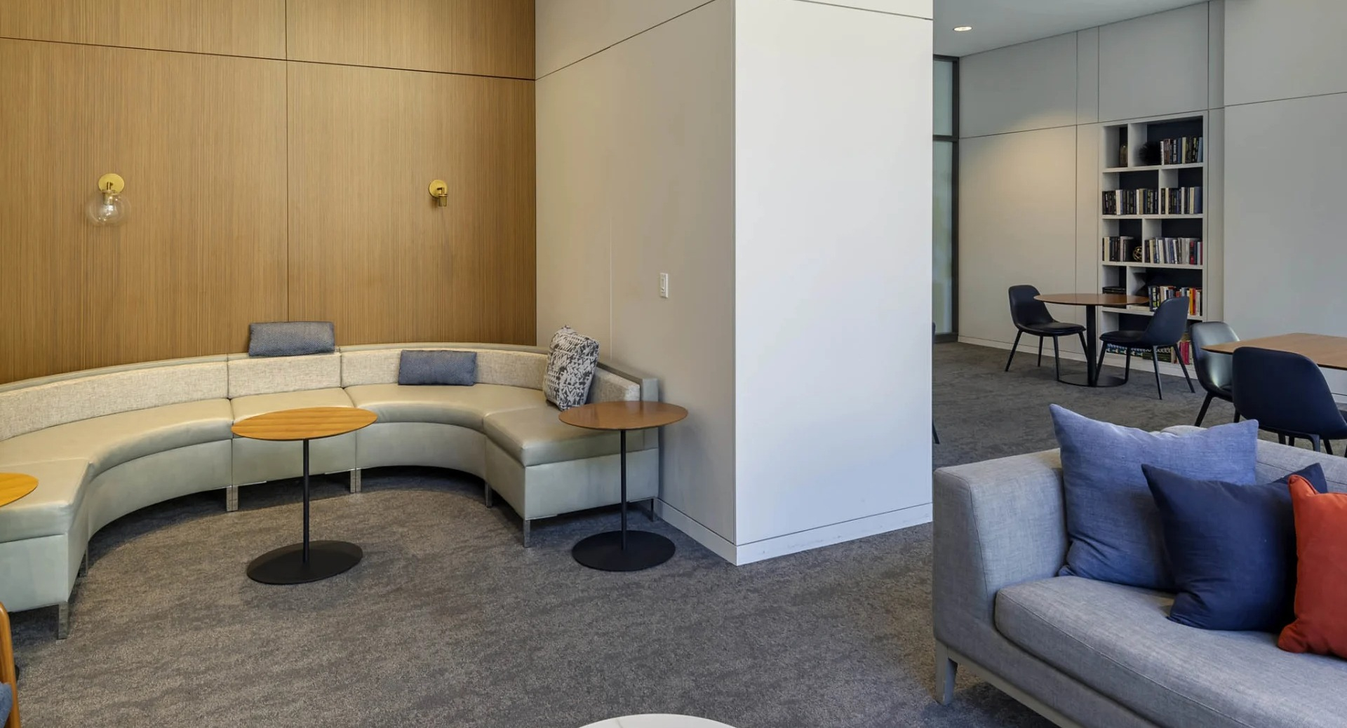 Cozy lounge at North Harbor Tower in Chicago with curved banquette seating, modern sofas, accent pillows, and adjoining reading areas