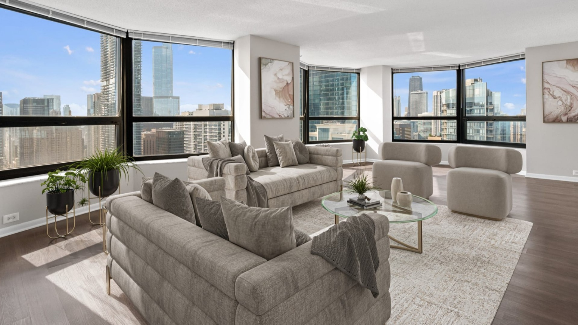 Spacious living room at North Harbor Tower with curved windows, modern gray seating, and sweeping Chicago skyline views flooding the space with light
