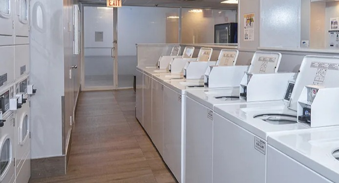 Laundry room at North Harbor Tower in Chicago with rows of washers and dryers, bright lighting, and spacious layout for resident convenience