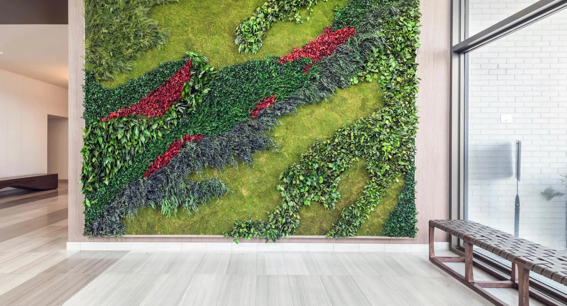 Elegant lobby at North Harbor Tower in Chicago featuring a striking living green wall with vibrant plants and a bench, creating a fresh, modern welcome for residents