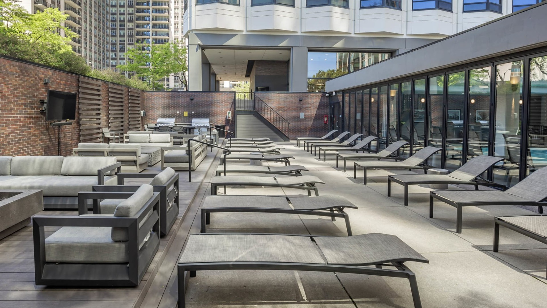 Outdoor sundeck at North Harbor Tower in Chicago featuring modern lounge chairs, comfortable sofas, and space for relaxation under the city skyline