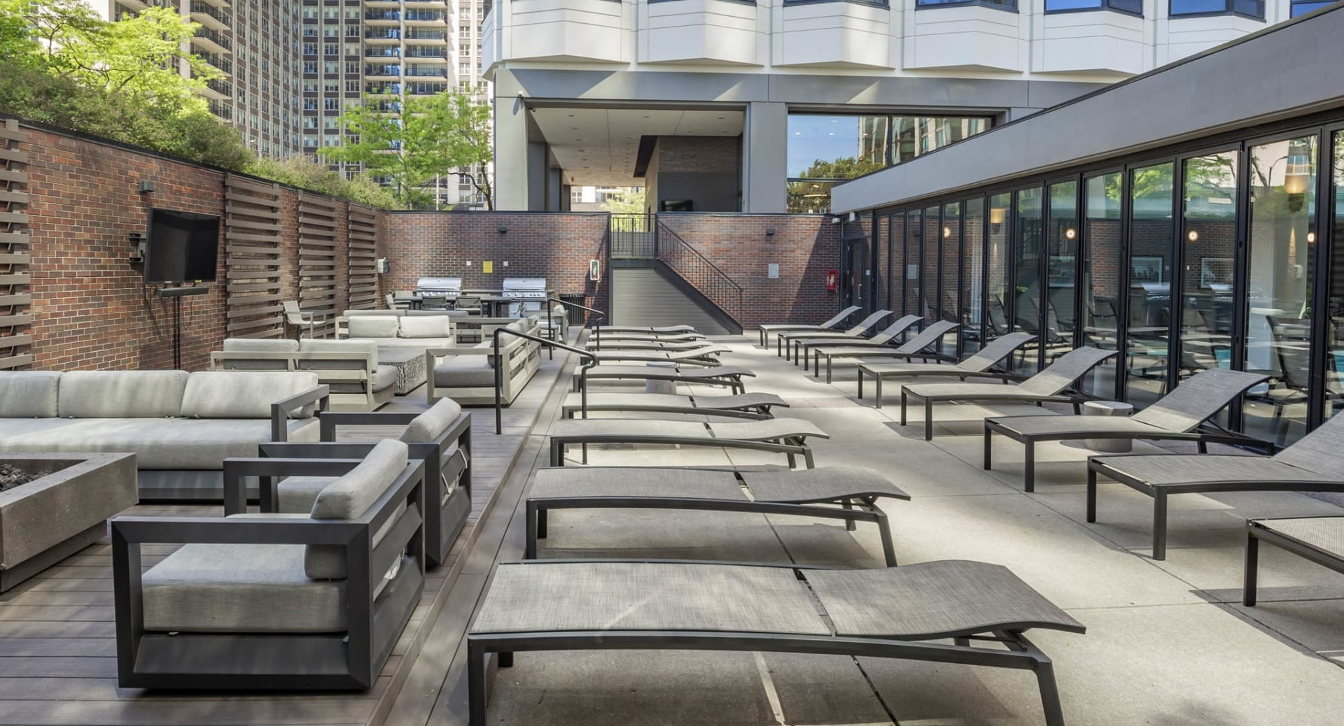 Outdoor sundeck at North Harbor Tower in Chicago featuring modern lounge chairs, comfortable sofas, and space for relaxation under the city skyline