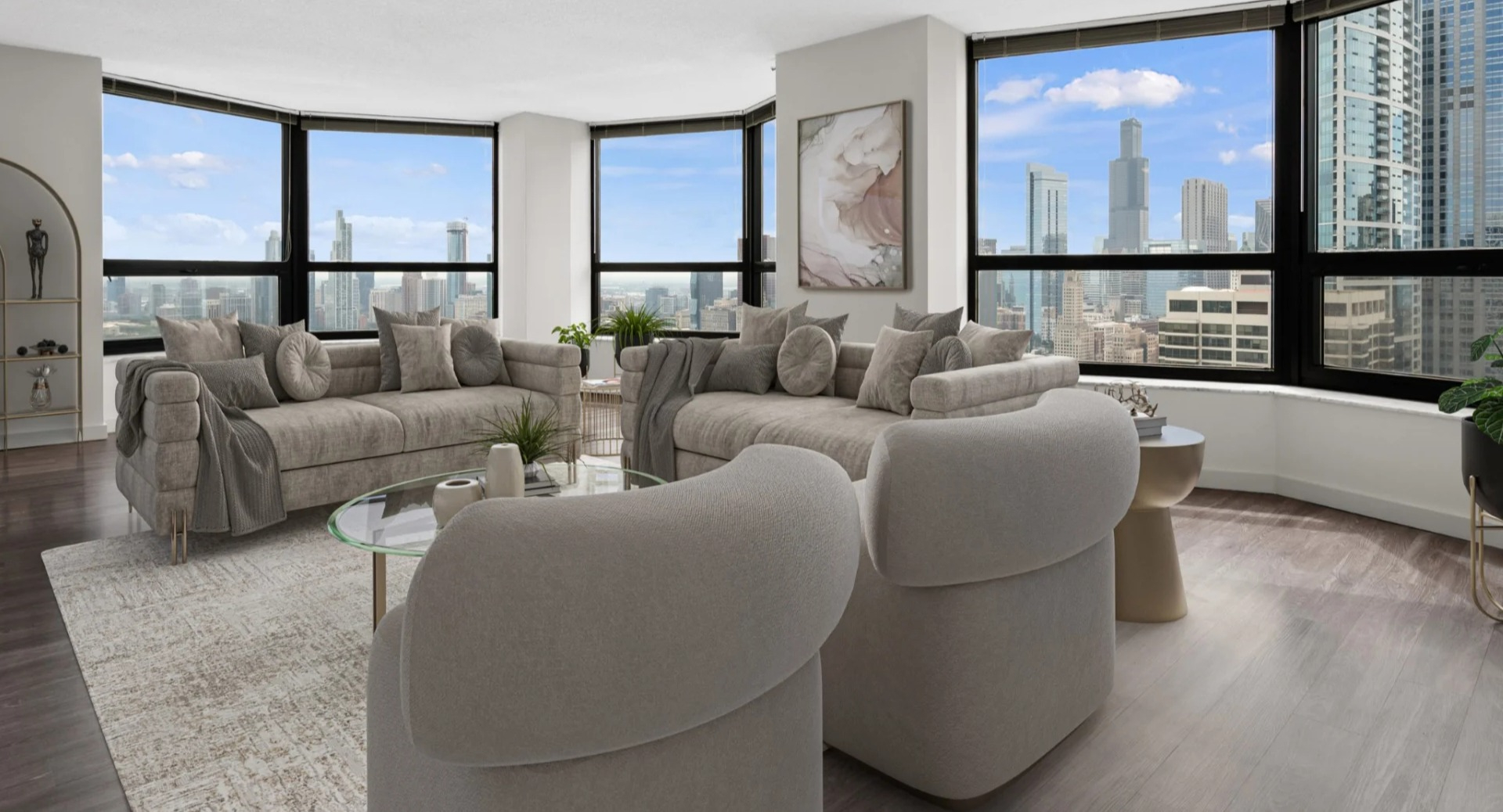 Bright, spacious living room at North Harbor Tower with modern sofas, glass coffee table, and panoramic Chicago skyline views from large corner windows