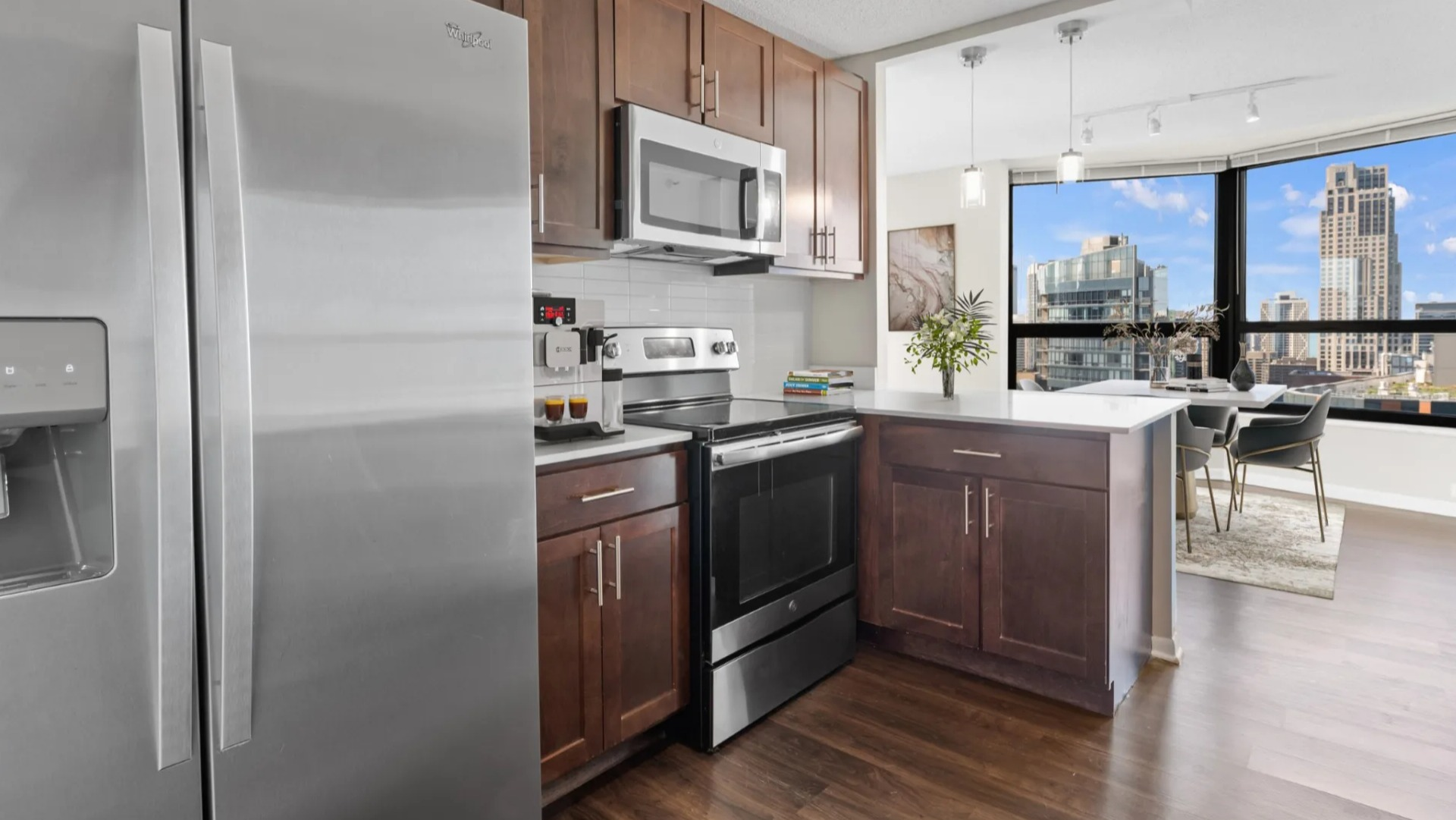 Open studio at North Harbor Tower combining a cozy bed, chic sofa, dining nook, and large windows showcasing downtown Chicago cityscape views