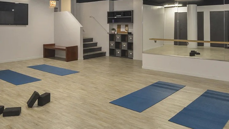 Yoga and fitness studio at North Harbor Tower in Chicago with mirrored walls, wood floors, yoga mats, and open space for group classes