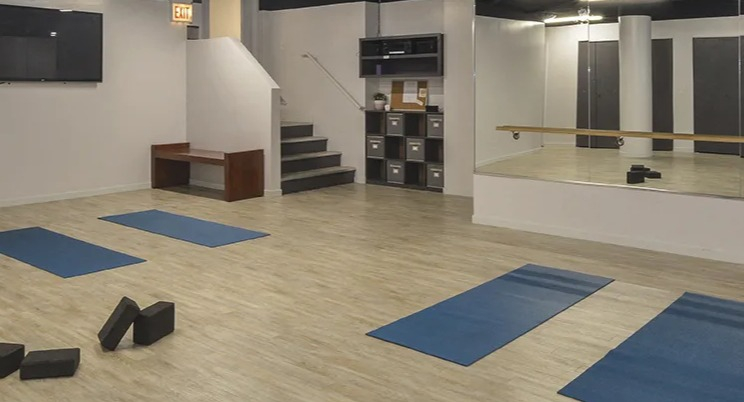 Yoga and fitness studio at North Harbor Tower in Chicago with mirrored walls, wood floors, yoga mats, and open space for group classes