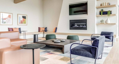 Inviting resident lounge area with a cozy fireplace, comfortable seating, and shelves adorned with decor at North+Vine in Chicago