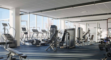Spacious gym with various strength training machines, free weights, and ample floor space for workouts at North+Vine in Chicago