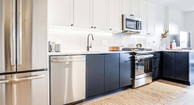 Contemporary kitchen with stainless steel appliances, two-tone cabinetry, and a subway tile backsplash, offering a sleek look at North+Vine in Chicago