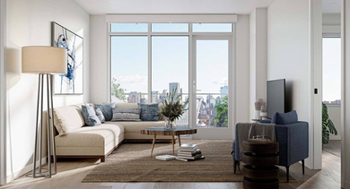 Inviting living room with a comfortable sectional, modern floor lamp, and a large window leading to a balcony with city views at North+Vine in Chicago