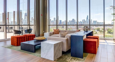 Luxurious resident lounge with comfortable seating, modern decor, and expansive windows offering stunning city views at North+Vine in Chicago