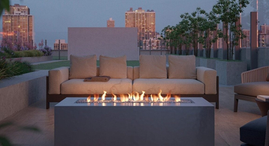 Inviting rooftop fire pit area with comfortable outdoor sofas, lit flames, and a city view at dusk at North+Vine in Chicago